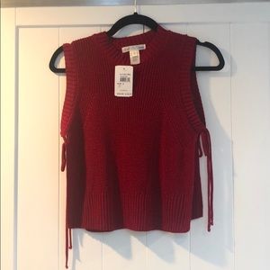 Sleeveless red sweater with side cutouts